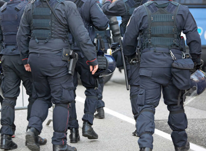 Police,In,Riot,Gear,With,Protective,Helmet,Waiting,For,The