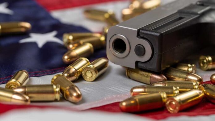 Detail,Of,Gun,Barrel,With,Many,Bullets,On,American,Flag.