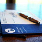 Absentee ballot envelopes with pen on table.