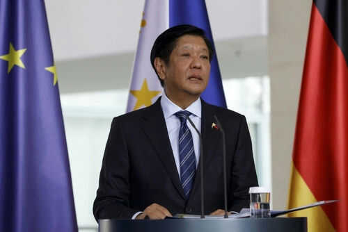 Man in suit speaking near European Union flags