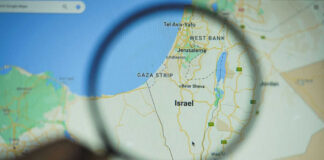 Magnifying glass focusing on Israel on a map.