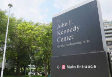 Kennedy Center sign with trees and building background
