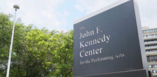 Kennedy Center sign with trees and building background