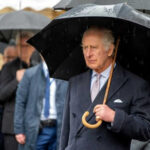 Man holding umbrella in rainy weather with crowd