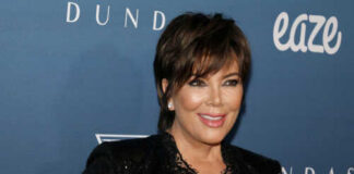 A woman in a glamorous outfit smiling at a celebrity event