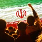 Regime’s New Weapon—Crying “Foreign Plot” to Stay in Power Crowd of people with their hands raised in front of the Iranian flag