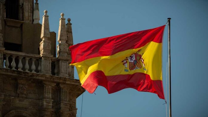 Spanish flag waving against a clear blue sky