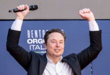 Person with a microphone raising hands in celebration