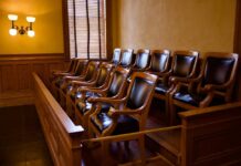 Courtroom SHOCKER: Secrecy Battle in Charlie Kirk Case Empty jury box with wooden chairs in a courtroom