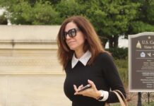 A woman in sunglasses walking near the U.S. Capitol