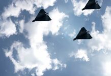 Three drones flying in a cloudy sky