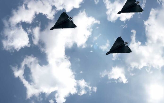 Three drones flying in a cloudy sky