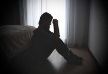 Powerful Investigation: Abortion Pill Dangers Unveiled A silhouette of a woman sitting on the floor, looking contemplative near a window