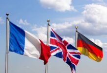 Europe War Signal SHOCKS Iran Standoff Flags of France, the United Kingdom, and Germany waving against a blue sky