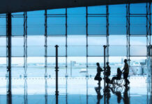 People at airport with wheelchair and reflections on floor