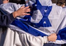 Missile Barrages FORCE Tel Aviv into Underground Living People holding an Israeli flag together, showcasing unity and cultural pride