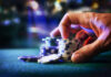 Hand stacking poker chips on casino table