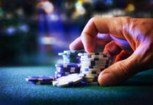 Hand stacking poker chips on casino table