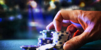 Hand stacking poker chips on casino table