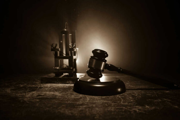 Gavel and electric chair in dimly lit room