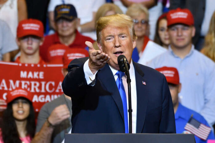 donald-trump-gestures-to-the-media1148319818jpg Man speaking at rally with crowd behind him