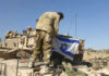 Soldiers setting Israeli flag on military vehicle tank