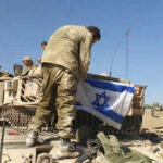 Soldiers setting Israeli flag on military vehicle tank