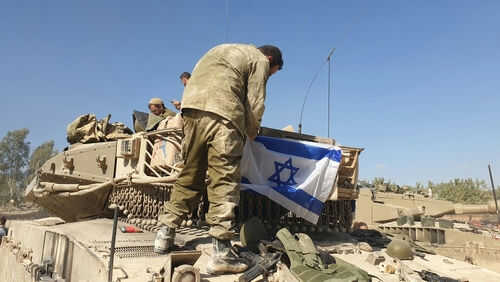 Soldiers setting Israeli flag on military vehicle tank