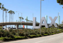 LAX sign with palm trees and blue sky