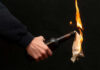 Person holding molotov cocktail with flame burning cloth