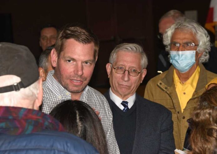 shutterstock_2269542073.jpg A group of people engaged in a discussion at a political event