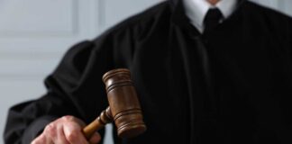 A judge holding a gavel above a wooden block