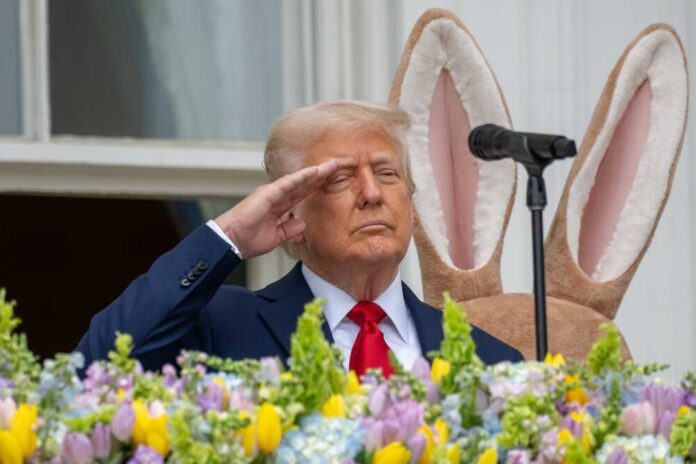 A man in a suit saluting in front of a floral display during an Easter event