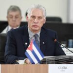 Cuban representative at a political meeting with a flag on the table