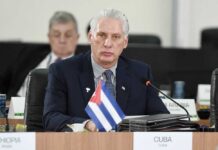 Cuban representative at a political meeting with a flag on the table