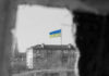 Ukraine flag on building seen through dark frame.