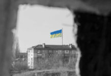 Ukraine flag on building seen through dark frame.