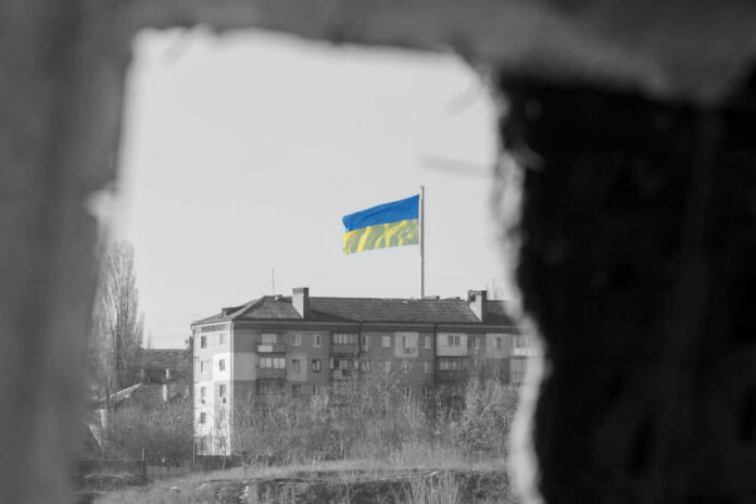 Ukraine flag on building seen through dark frame.