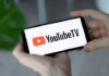Hands holding phone with YouTube TV logo displayed