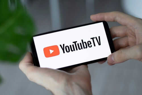 Hands holding phone with YouTube TV logo displayed
