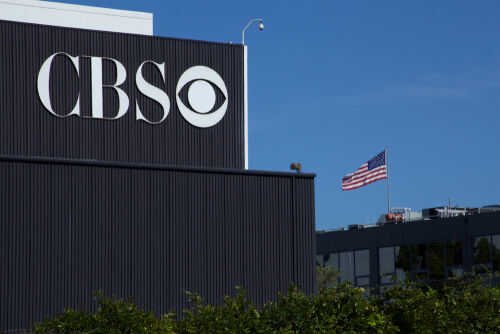 1491307826 CBS sign on building, American flag in background.