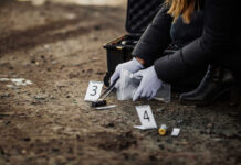 Person collecting evidence at a crime scene outdoors