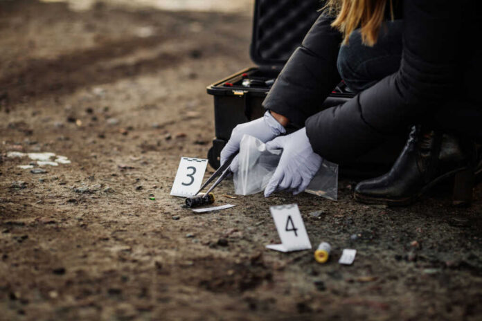 Person collecting evidence at a crime scene outdoors