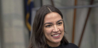 A person smiling, wearing a black shirt.