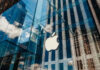 Apple store glass building with cloudy sky reflection