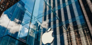 Apple store glass building with cloudy sky reflection