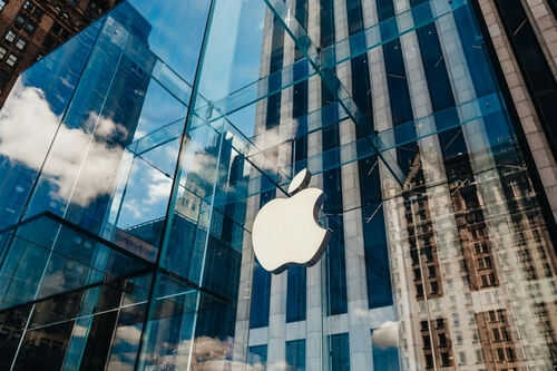 Apple store glass building with cloudy sky reflection