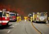 CALIFORNIA BURNING: State Policies Come Under Fire Firefighters battling large wildfire with fire trucks present