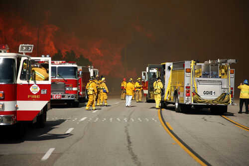 california-fire-fighter20701837-1 Firefighters battling large wildfire with fire trucks present