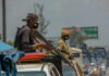Armed security personnel on vehicles in traffic jam